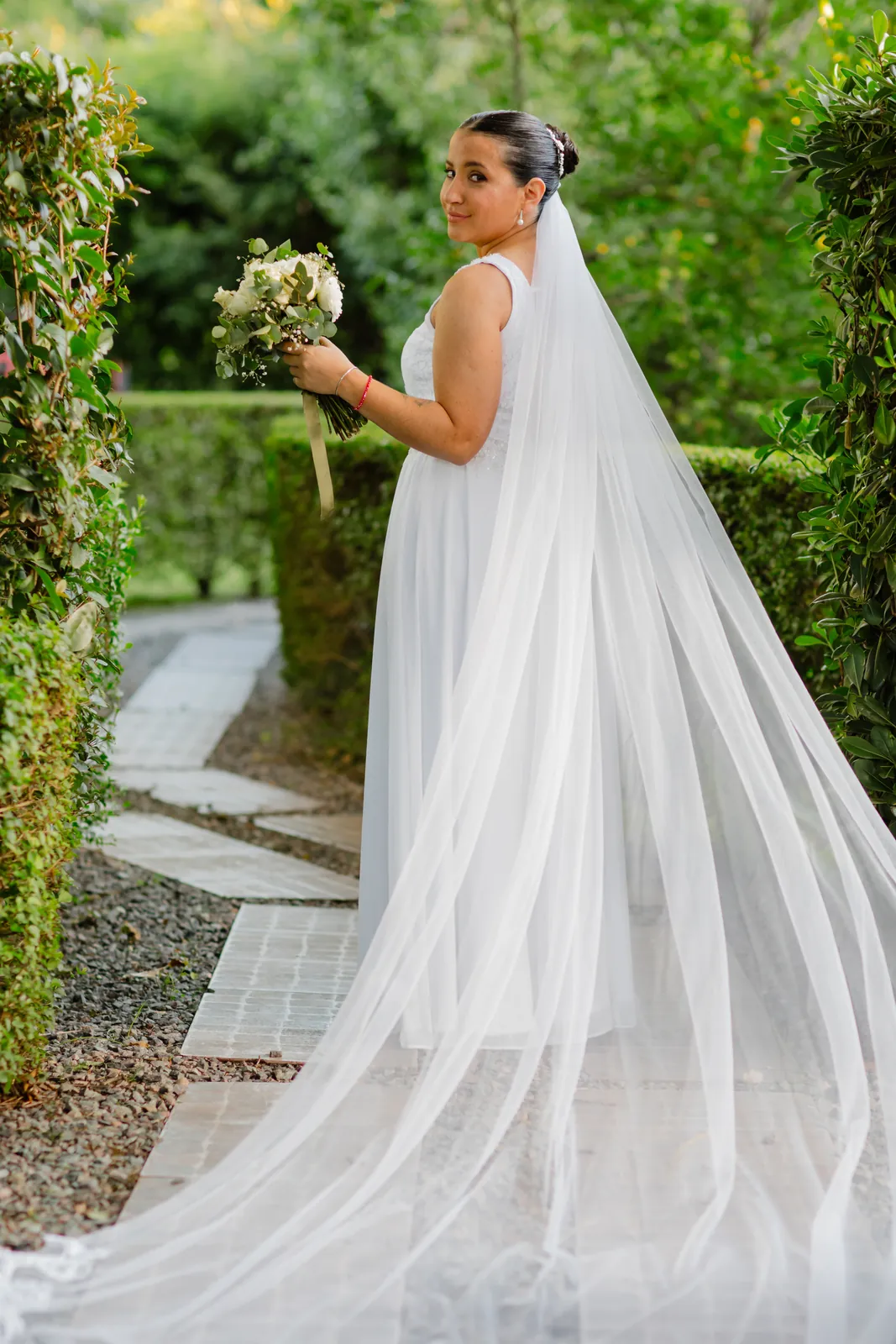 Novia con velo largo en el jardín — CBM Estudio